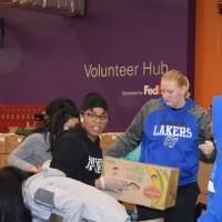 Photo of students working hard packing boxes at food bank